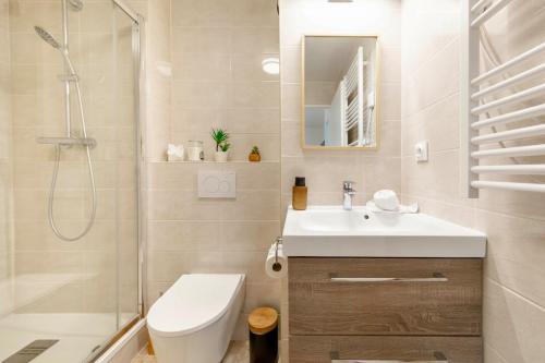 a bathroom with a toilet and a sink and a shower at Séjour magique à 10 min de Disneyland- Appartement cosy avec terrasse & parking privé in Bailly-Romainvilliers