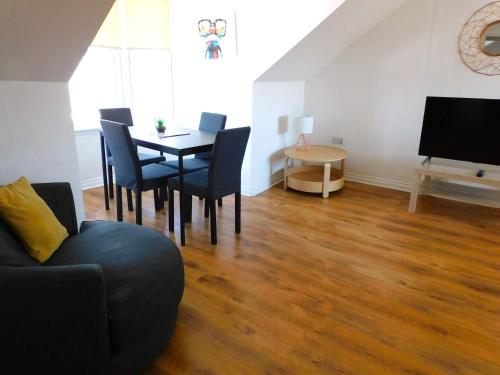 a living room with a table and chairs and a television at No 11 - Contemporary 2 Bedroom Apartment in Lanark Town Centre in Lanark