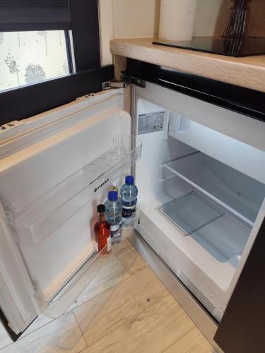 an open refrigerator with bottles of water in it at Little Tiny Village Haus 1 in Fußach