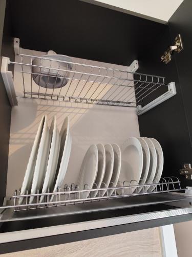 a rack of white dishes in a refrigerator at Little Tiny Village Haus 1 in Fußach