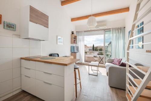une cuisine avec un comptoir et un salon dans l'établissement AS25806-P2 cabine duplex avec terrasse et parking, au Grau-du-Roi