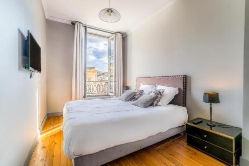 une chambre avec un grand lit et une fenêtre dans l'établissement Magnifique Appartement en Hypercentre avec Parking, à Bordeaux