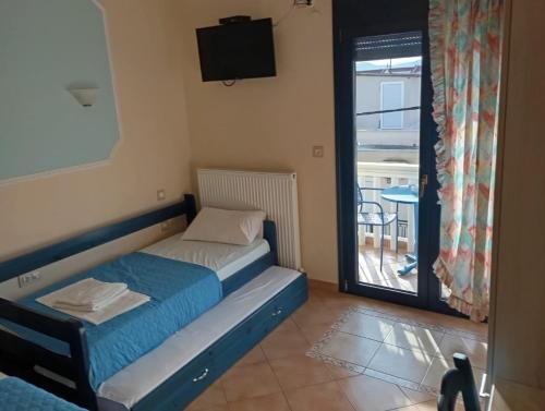 a small bed in a room with a balcony at Nea Peramos in Nea Peramos