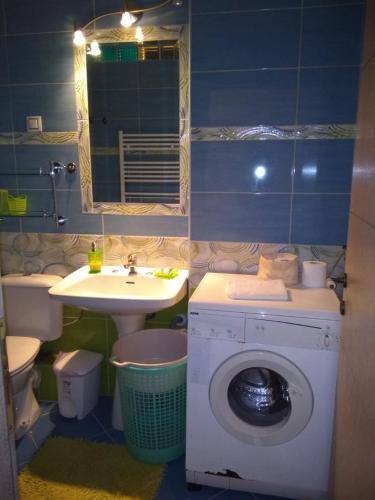 a bathroom with a washing machine and a sink at Nea Peramos in Nea Peramos