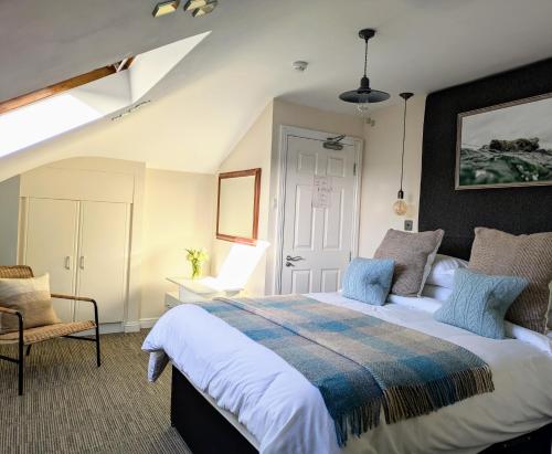クリフデンにあるHillside Lodge B&Bの大きなベッドと椅子のある寝室
