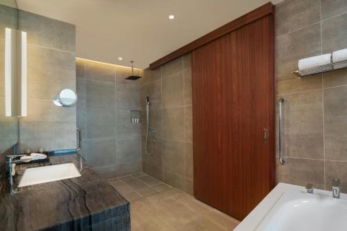 a bathroom with a tub and a sink and a shower at Le Meridien Putrajaya in Putrajaya