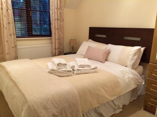 a bedroom with a bed with two towels on it at Woodside Self Catering Lough Rynn in Mohill