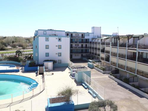 Cette chambre offre une vue sur un bâtiment doté d'une piscine. dans l'établissement Studio climatisé avec piscine, parking, terrasse, proche plage et commerces - FR-1-307-88, au Grau-du-Roi
