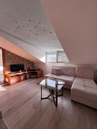 een woonkamer met een bank en een tafel bij Sasha Duplex Apartment in Skopje