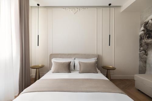 a bedroom with a large bed with white walls at Flòris Luxury Apartment NEW in Florence