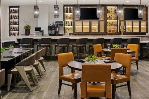 a restaurant with tables and chairs and a bar at Marriott Bloomington Normal Hotel and Conference Center in Bloomington