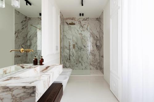 a bathroom with marble walls and a tub and a sink at Flòris Luxury Apartment NEW in Florence