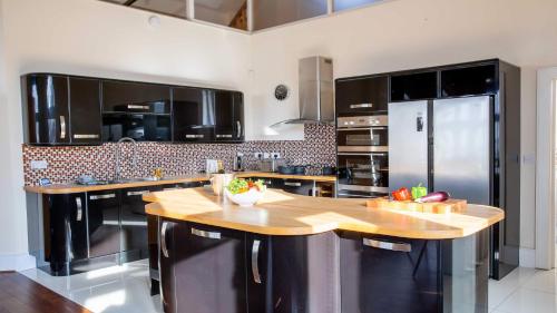 a kitchen with black cabinets and a wooden counter top at Post Office Penthouse in Great Yarmouth