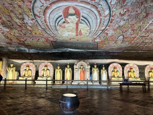 a room with a painting on the ceilings of a temple at Golden stars hotel Dambulla in Dambulla