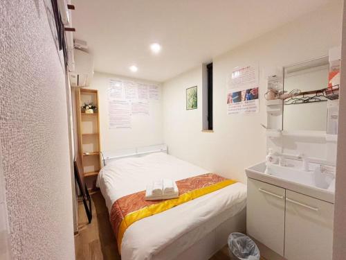 een kleine kamer met een bed en een wastafel bij Hananogo Ikebukuro - Vacation STAY 09224v in Tokyo
