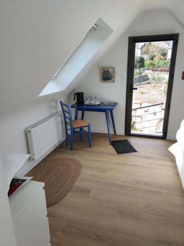 Cette chambre dispose d'une table bleue et d'une fenêtre. dans l'établissement Baradoz, à La Forêt-Fouesnant