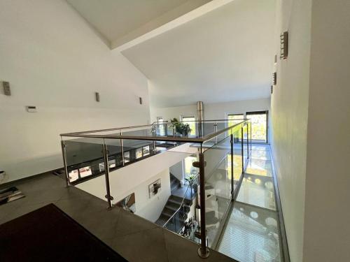 a glass staircase in a large white room with a stair case at Fantastic villa in Fischamend in Fischamend Dorf