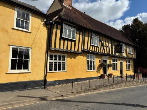 a yellow building with white windows on a street at The Crown, Bildeston in Bildeston