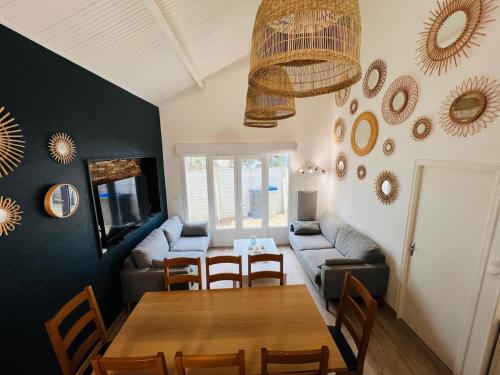 un salon avec une table et un canapé dans l'établissement A l'ombre des pins, à La Terrière