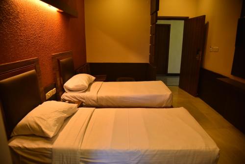 a hotel room with two beds in a room at Shaheen Bagh - A Luxury Boutique Resort & Spa in Rājpur