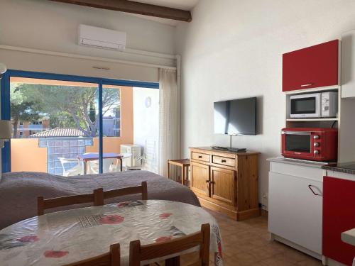 Cette petite chambre comprend un lit et une cuisine avec une table. dans l'établissement Studio cosy avec terrasse, parking, proche thermes - Balaruc-les-Bains - FR-1-553-89, à Balaruc-les-Bains