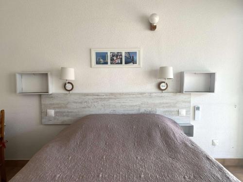 une chambre avec un lit et deux lampes au mur dans l'établissement Studio cosy avec terrasse, parking, proche thermes - Balaruc-les-Bains - FR-1-553-89, à Balaruc-les-Bains