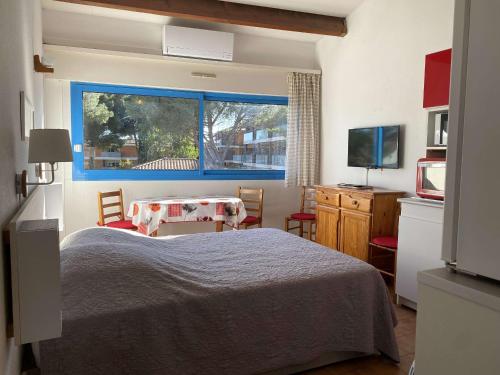 une chambre avec un lit, une table et une fenêtre dans l'établissement Studio Confort 2* avec 2 Parkings Privés, Proche Thermes, Calme et Bien Équipé - Balaruc-les-Bains - FR-1-553-114, à Balaruc-les-Bains