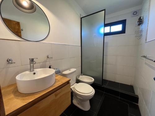 a bathroom with a sink and a toilet and a mirror at Dread Chapa Shack Casa 1 - Casa en Chapadmalal para 6 PX - Hola sur in Chapadmalal