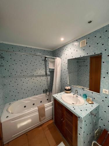 a bathroom with a bath tub and a sink at Seazimbra - Luxury Apartment in Sesimbra