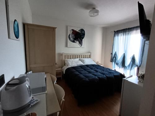 a bedroom with a bed with a blue blanket and a window at Prati di Maja B&B in Miglianico
