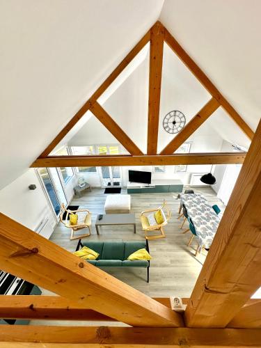 Cette chambre mansardée offre une vue sur un salon doté de poutres apparentes. dans l'établissement Le perchoir avec vue mer, à 300m de la plage, à Saint-Côme-de-Fresné