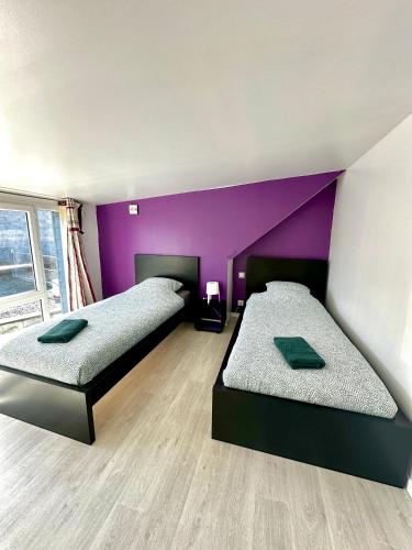 - 2 lits dans une chambre dotée d'un mur violet dans l'établissement Le perchoir avec vue mer, à 300m de la plage, à Saint-Côme-de-Fresné
