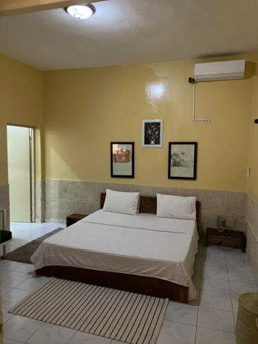 a bedroom with a large bed with white sheets at Chez saly in Saint-Louis