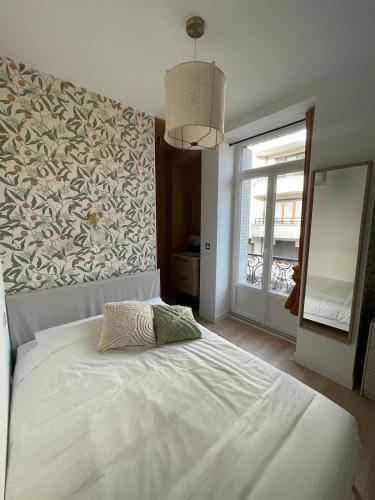 - une chambre avec un grand lit blanc et une grande fenêtre dans l'établissement Le Darcy - Entre Gare et Ville, à Dijon