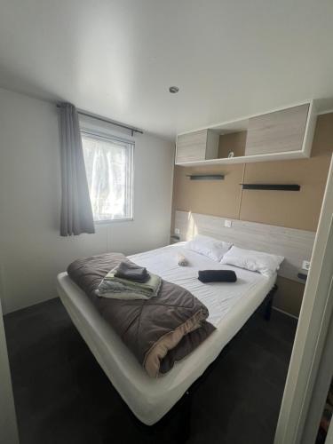 une chambre avec un grand lit dans une pièce dans l'établissement Mobilhome 6 couchages grand confort Cap Ferret, à Lège-Cap-Ferret