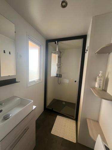 une salle de bain avec douche et lavabo dans l'établissement Mobilhome 6 couchages grand confort Cap Ferret, à Lège-Cap-Ferret