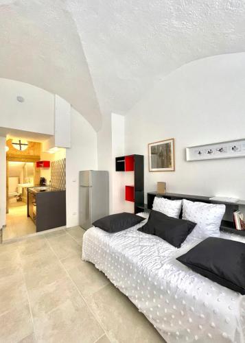 une chambre avec un grand lit et une cuisine dans l'établissement Hôtel Villard Studio Monument Historique Gard Tourisme, à Nîmes