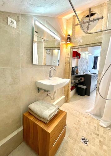 La salle de bains est pourvue d'un lavabo et d'une table en bois. dans l'établissement Hôtel Villard Studio Monument Historique Gard Tourisme, à Nîmes
