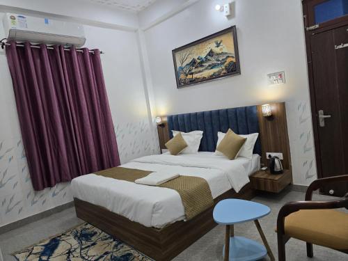 a bedroom with a bed and a red curtain at Hotel The Sky Blue & Caffe in Masodha
