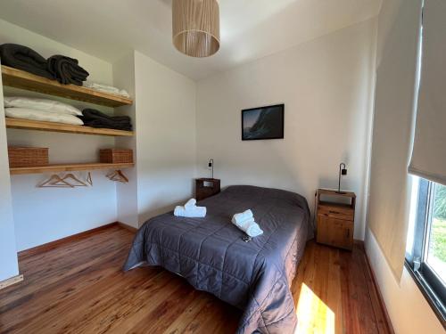a bedroom with a bed and a tv on the wall at Dread Chapa Shack Casa 2 - Casa en Chapadmalal - Hola Sur in Colonia Chapadmalal