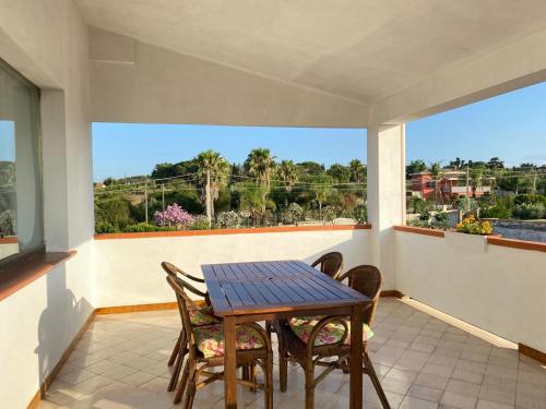 a dining room with a table and chairs and a large window at Quiet House - appartamento Maestrale in Porto Torres