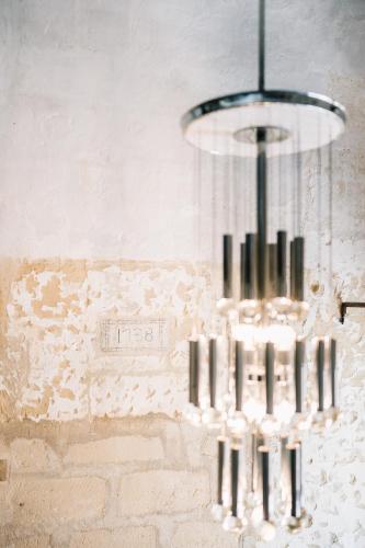 a chandelier hanging from a brick wall at Il Granile Contemporary Loft in Matera