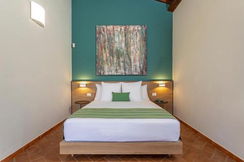 a bedroom with a bed and a painting on the wall at Feudogrande Bio Relais Hotel in Fiumefreddo di Sicilia
