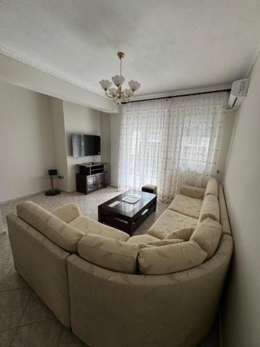 a living room with a large couch and a table at Lia Apartments 1 in Kallithea Halkidikis