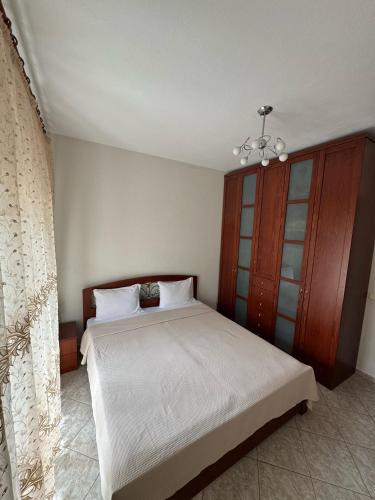 a bedroom with a bed and a wooden cabinet at Lia Apartments 1 in Kallithea Halkidikis
