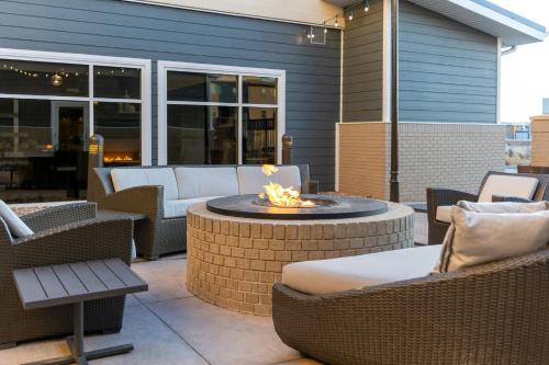 a patio with a fire pit with chairs and tables at Residence Inn by Marriott Denver Central Park in Denver