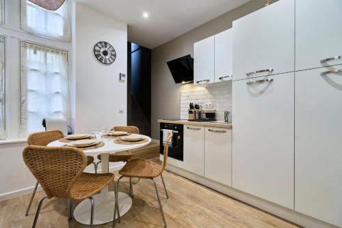 une cuisine et une salle à manger avec une table et des chaises dans l'établissement Appartement Central et Tout Equipé - 2 - Mon Groom, à Troyes