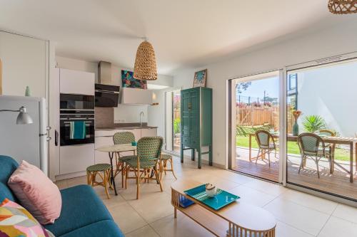 un salon avec un canapé bleu et une table dans l'établissement ETXETXOA Appartement lumineux avec jardin au cœur de Chiberta, à Anglet