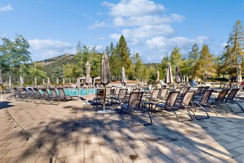 a group of chairs and umbrellas next to a pool at Everline #350 in Olympic Valley