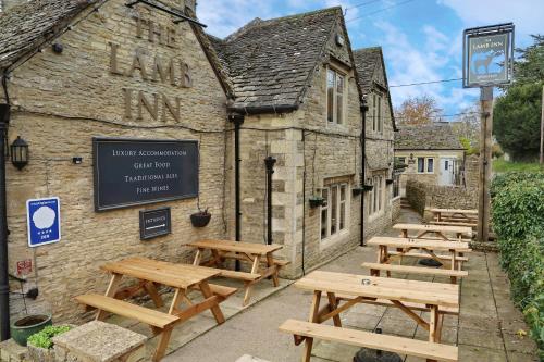 a group of picnic tables outside of a building at The Lamb Inn in Cheltenham